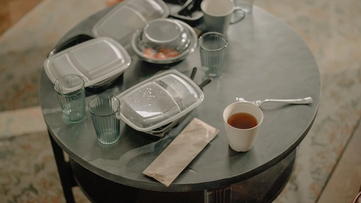 Table covered with leftover food in takeaway containers