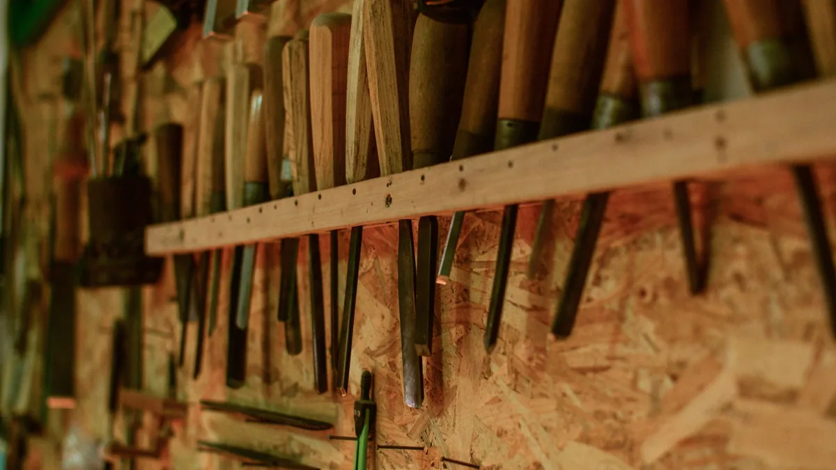 Rows of chisels and woodworking tools hanging on a workshop wall