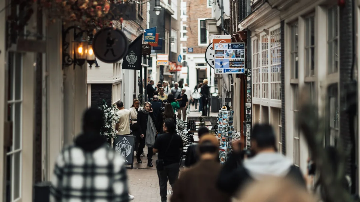 People walking down a narrow street lined with small shops