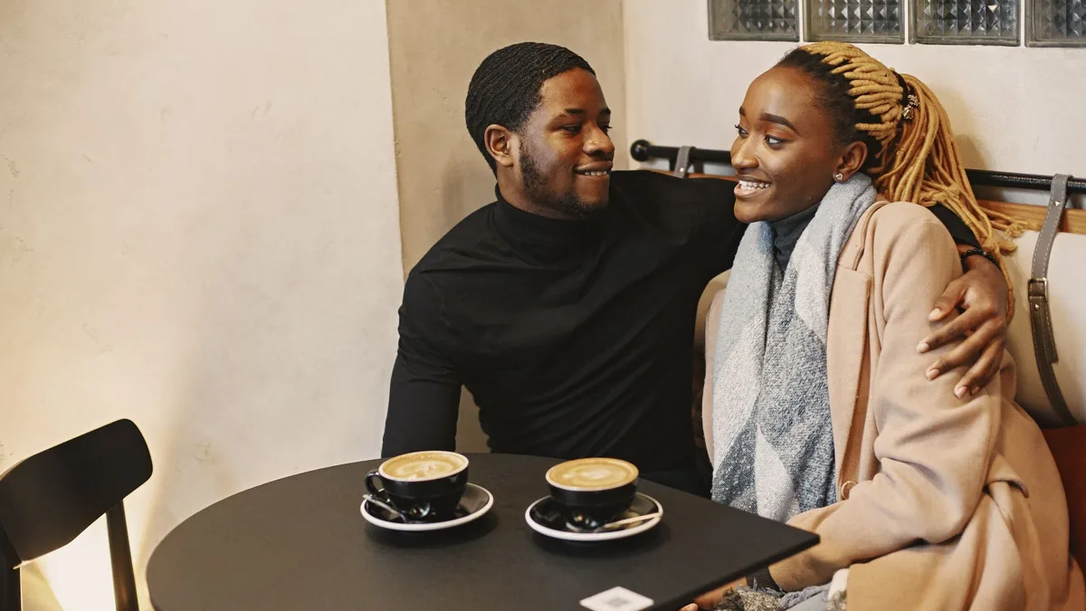 Couple sharing a laugh over coffee in a café