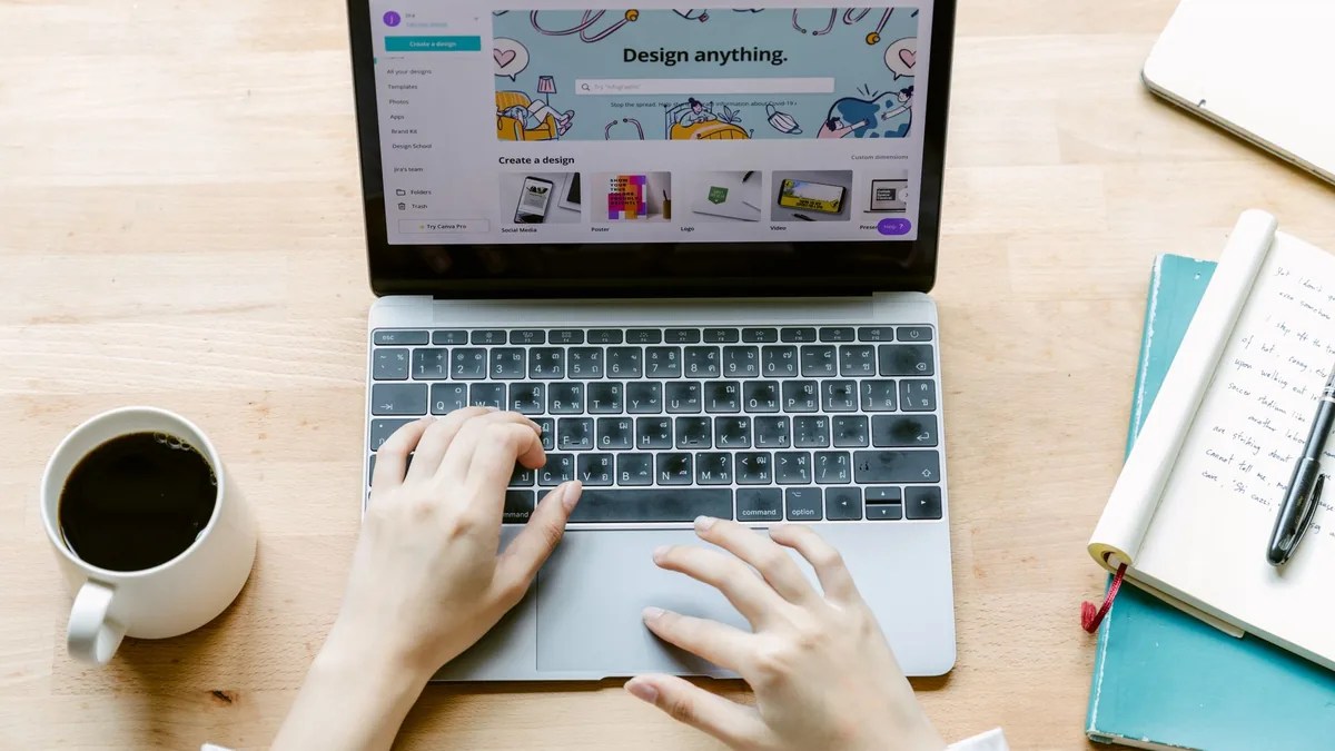 Overhead view of hands on a laptop showing an online shop, with coffee and notebooks