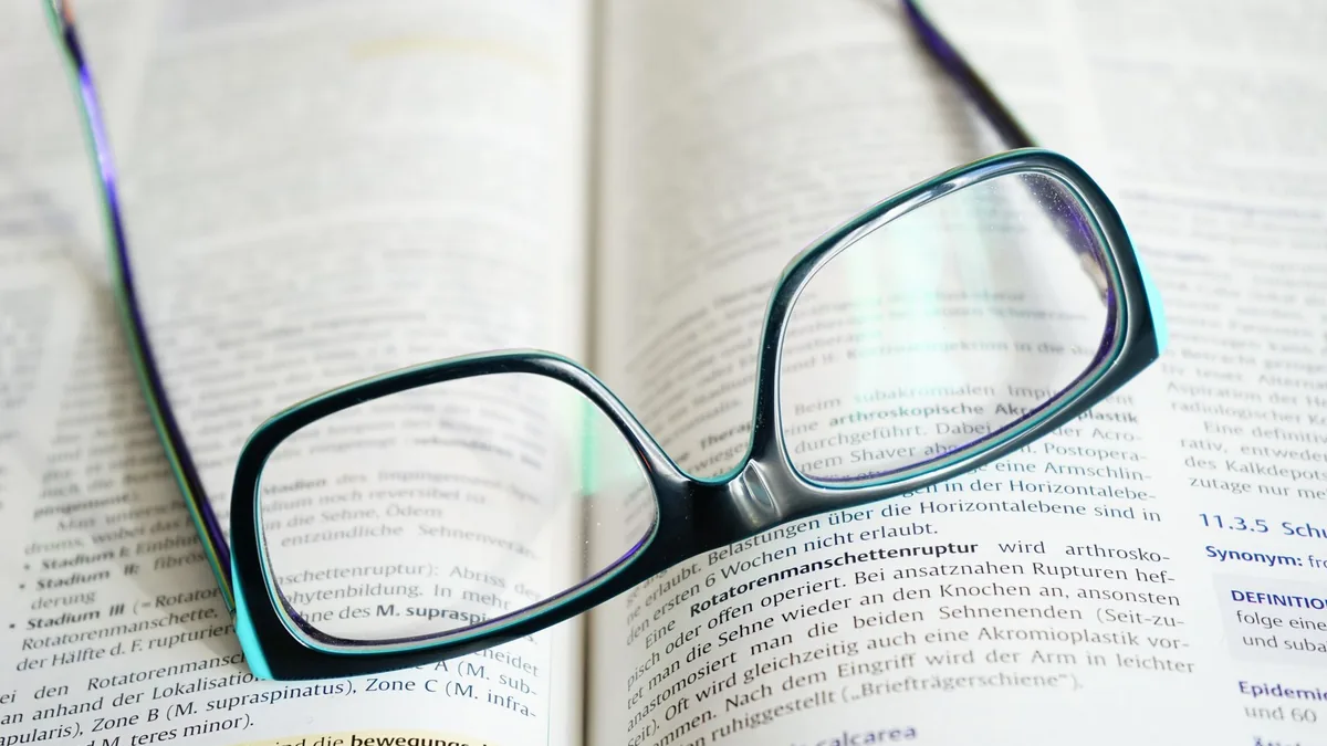 Reading glasses resting on an open book