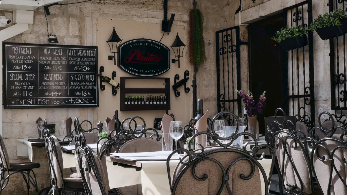 Outdoor tables of a small bistro on a sunny old-town street