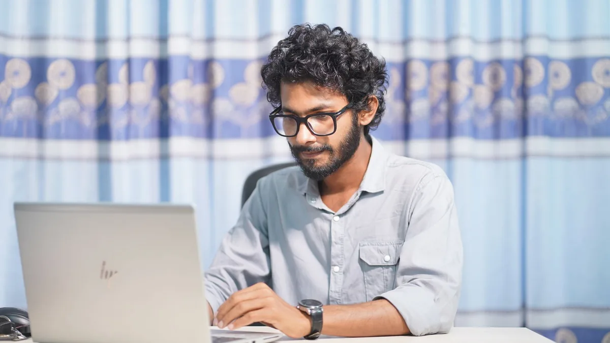 Young man working on a laptop in a bright room