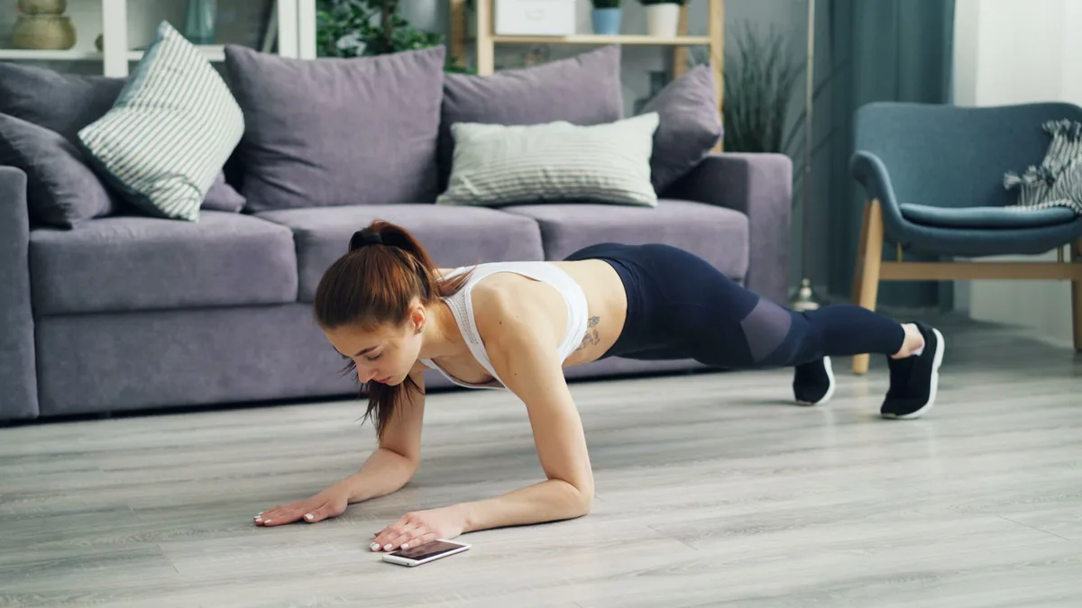Woman doing a plank exercise on a mat in her living room
